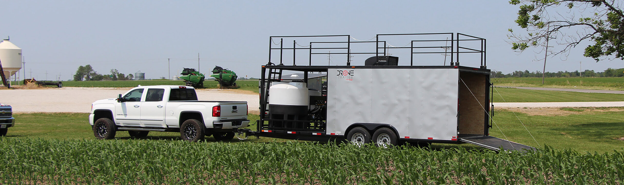 Agricultural drone trailer with tanks and top rails in use in the field